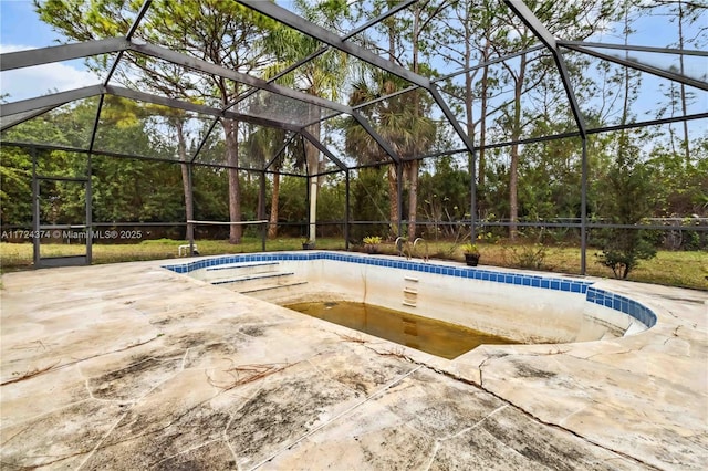 view of pool with a patio area and glass enclosure