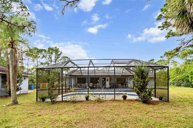 back of house with a lanai and a yard