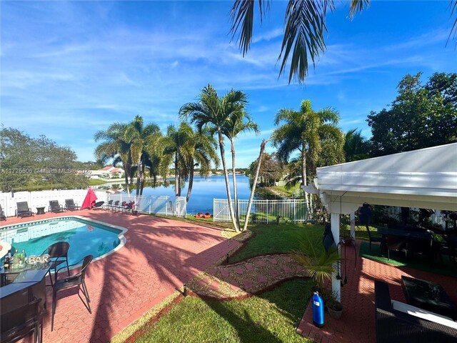 view of swimming pool featuring a water view and a patio area