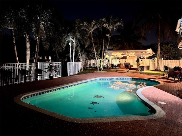 pool at twilight featuring a patio