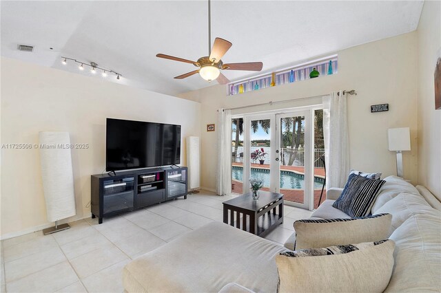 tiled living room featuring french doors and ceiling fan