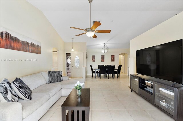 living room featuring lofted ceiling, light tile patterned floors, and ceiling fan