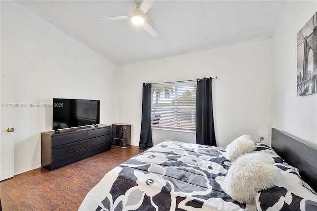 bedroom with dark wood-type flooring, vaulted ceiling, and ceiling fan