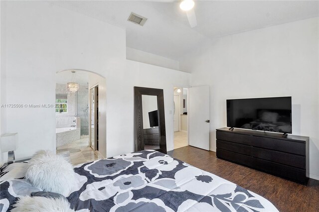 bedroom featuring dark wood-type flooring, ceiling fan, ensuite bathroom, and lofted ceiling