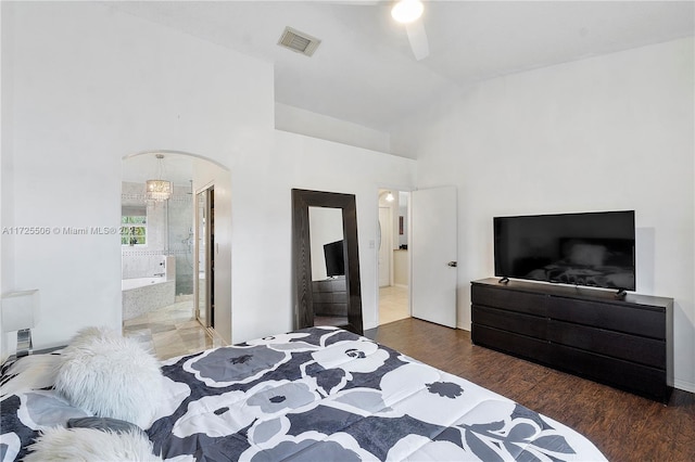 bedroom featuring dark hardwood / wood-style flooring, ceiling fan, high vaulted ceiling, and ensuite bathroom