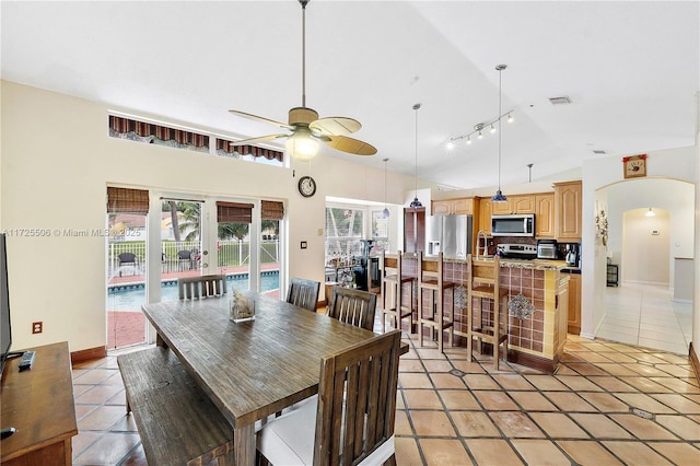 tiled dining space featuring french doors, vaulted ceiling, ceiling fan, and track lighting