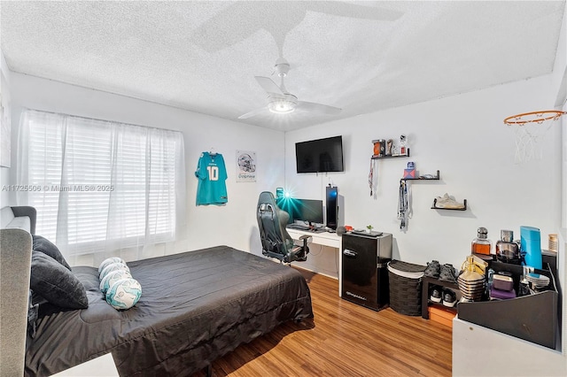 bedroom with a textured ceiling, hardwood / wood-style floors, and ceiling fan