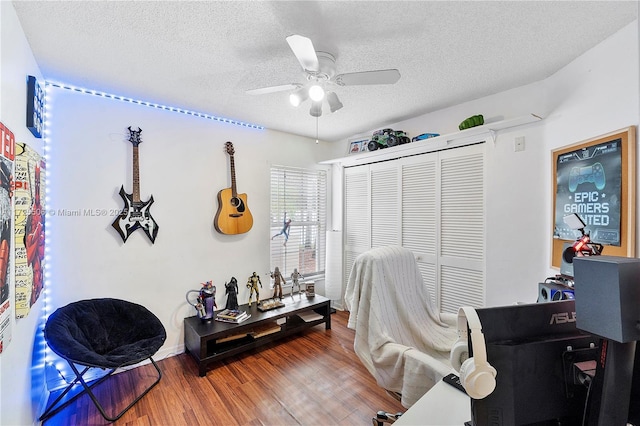 office space featuring ceiling fan, hardwood / wood-style flooring, and a textured ceiling