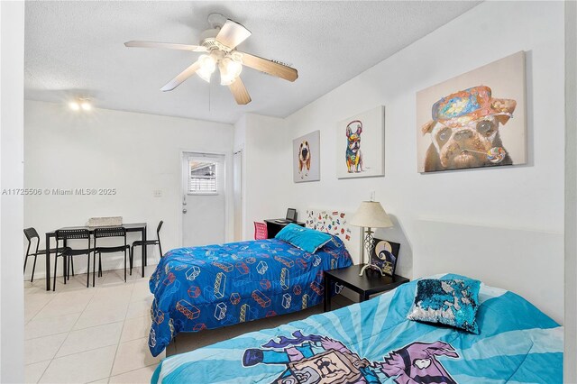 tiled bedroom featuring ceiling fan and a textured ceiling