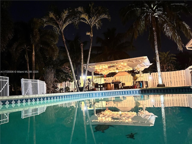 view of pool at twilight