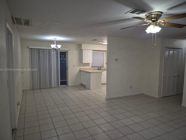 unfurnished room featuring ceiling fan with notable chandelier, sink, and light tile patterned floors