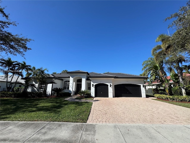 mediterranean / spanish-style home featuring a garage and a front yard