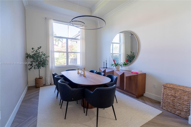 dining space featuring ornamental molding and light parquet flooring