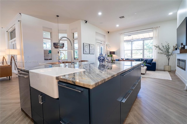 kitchen featuring a large island, sink, pendant lighting, and dishwasher