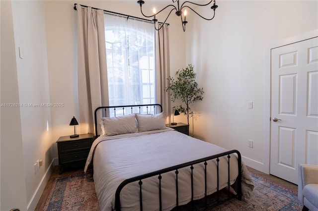 bedroom featuring dark hardwood / wood-style floors and a notable chandelier