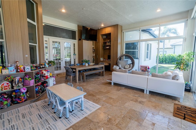 interior space with wooden walls, french doors, and a textured ceiling