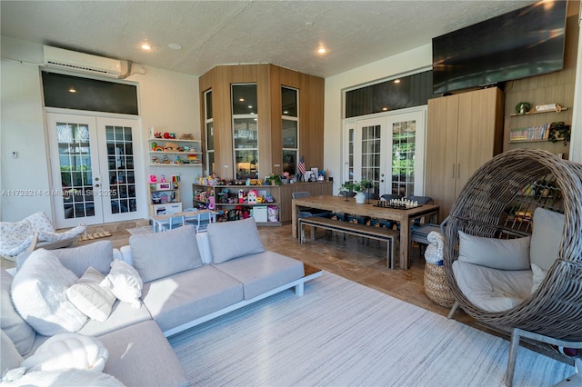 living room featuring french doors, a textured ceiling, and an AC wall unit