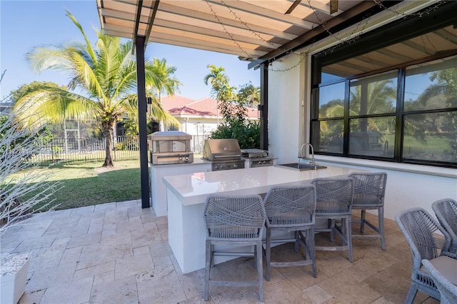 view of patio featuring an outdoor kitchen, a grill, and a wet bar