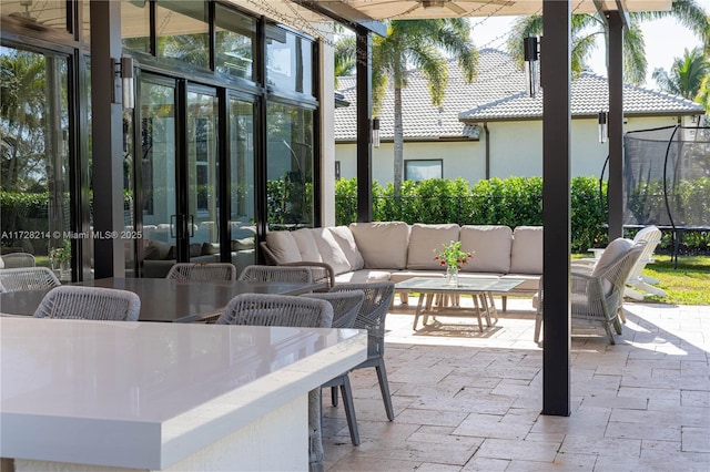 view of patio / terrace with a trampoline, an outdoor living space, and ceiling fan