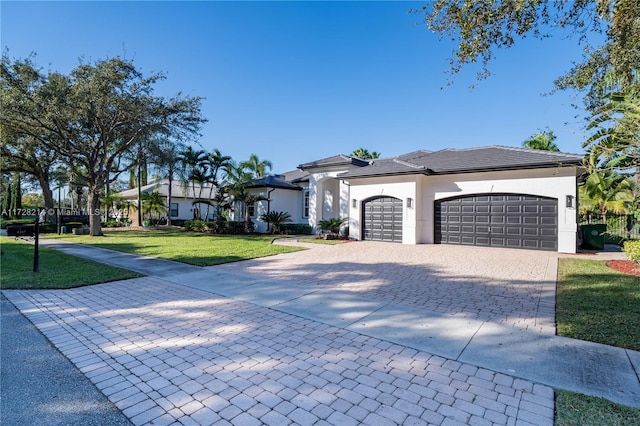 view of front of home with a garage and a front lawn