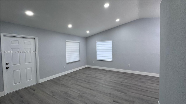 unfurnished room with dark hardwood / wood-style floors and vaulted ceiling