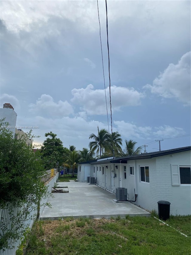 rear view of house with central AC and a patio area