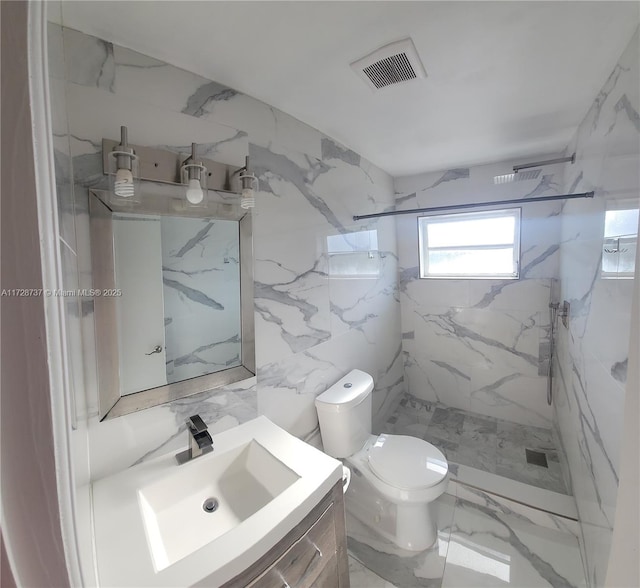 bathroom featuring toilet, a tile shower, and vanity