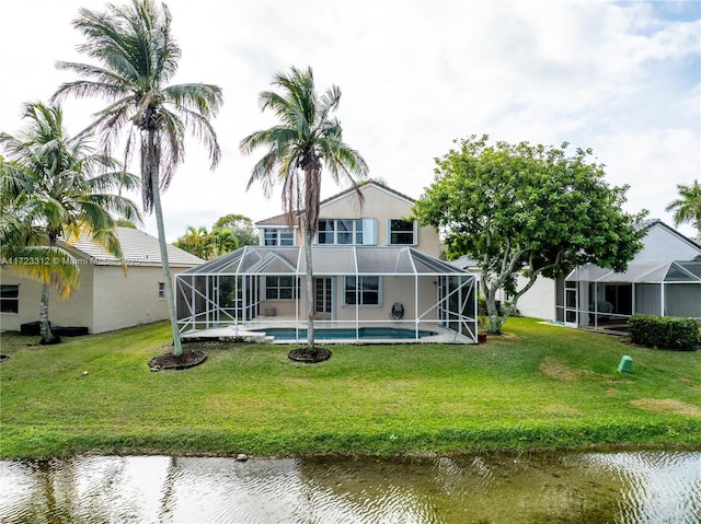 back of house featuring a lanai, a water view, and a yard