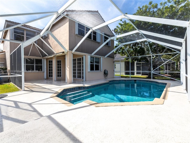 view of pool featuring glass enclosure and a patio area