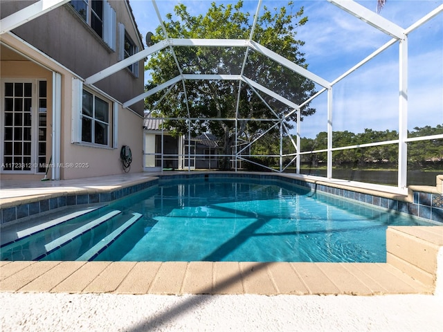 view of swimming pool featuring a patio area and glass enclosure