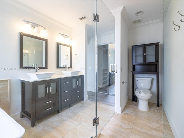 bathroom with toilet, vanity, and ornamental molding