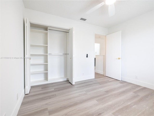 unfurnished bedroom with ceiling fan, light hardwood / wood-style floors, and a closet