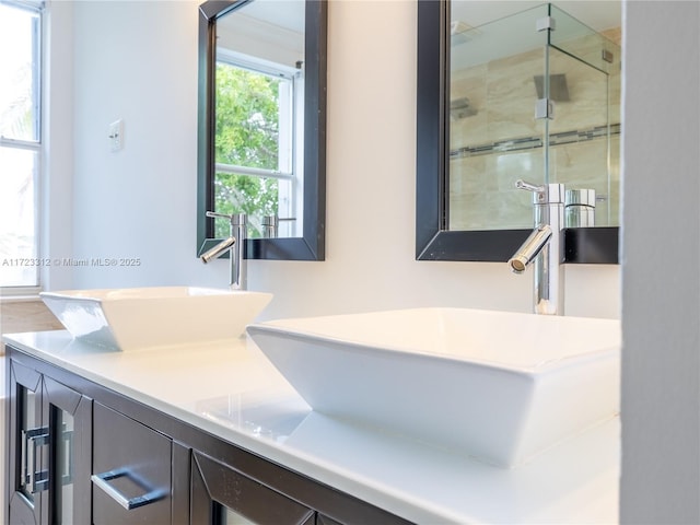 bathroom with a shower with shower door and vanity