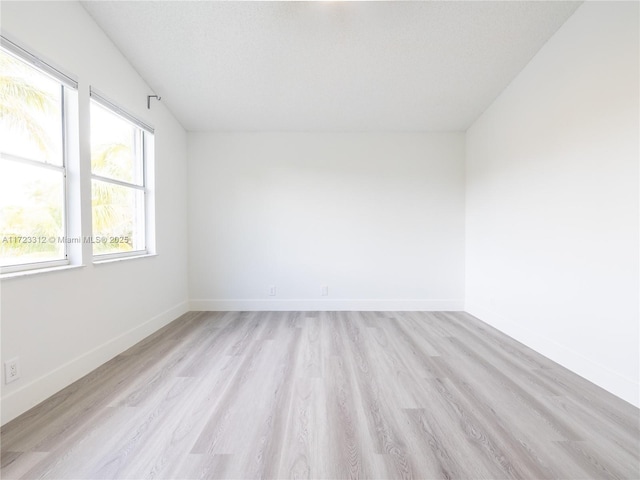 unfurnished room featuring a textured ceiling and light hardwood / wood-style flooring