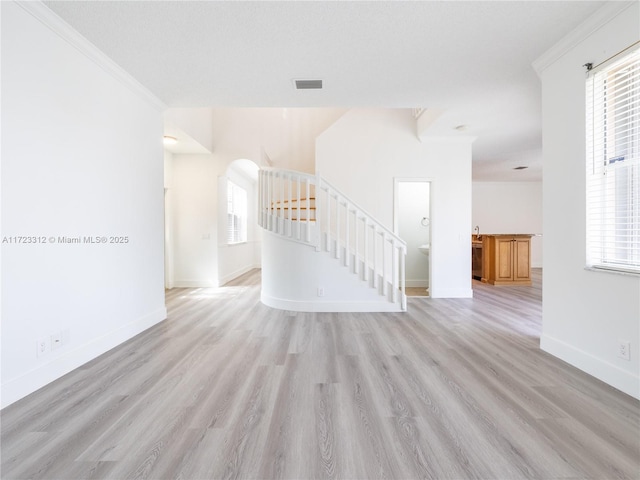 spare room with ornamental molding and light hardwood / wood-style flooring