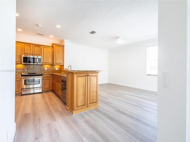 kitchen with backsplash, light hardwood / wood-style floors, kitchen peninsula, sink, and stainless steel appliances