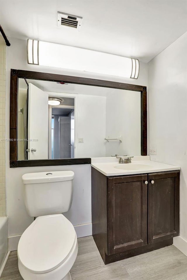 bathroom with wood-type flooring, toilet, and vanity