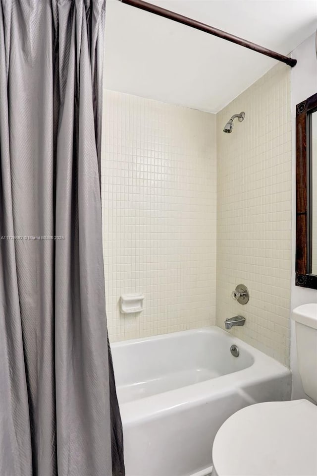 bathroom featuring toilet and shower / tub combo with curtain