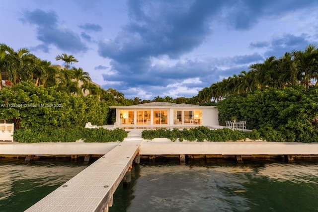 back of property featuring a water view and a patio