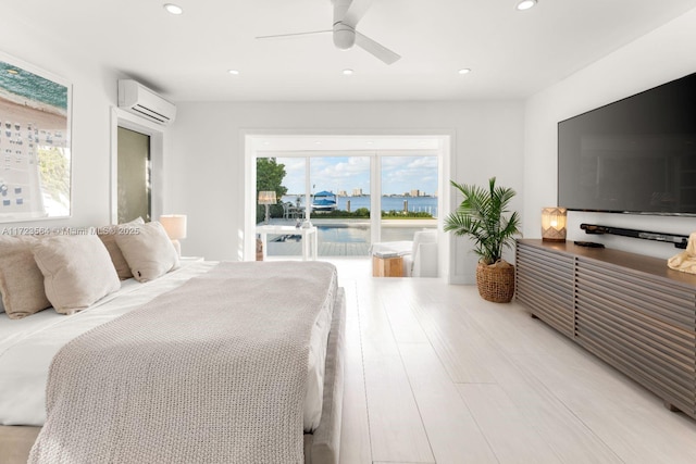 bedroom featuring ceiling fan, light hardwood / wood-style floors, access to outside, and a wall mounted air conditioner