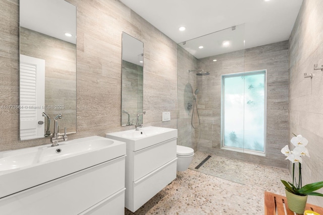 bathroom featuring a shower, tile walls, toilet, and vanity