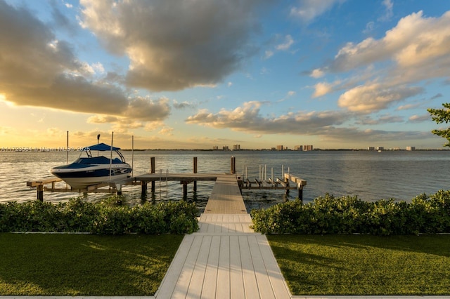 view of dock featuring a lawn and a water view