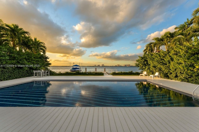 1065 N Shore Dr, Miami Beach, FL 33141 - pool at dusk with a water view, an outdoor pool, and a patio area