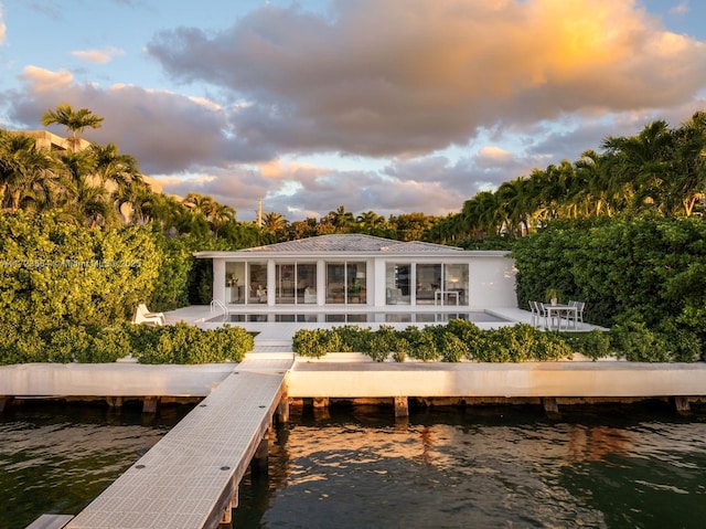 1065 N Shore Dr, Miami Beach, FL 33141 - back of house at dusk with a water view and a patio