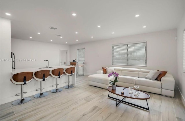 living room featuring light wood-type flooring and sink