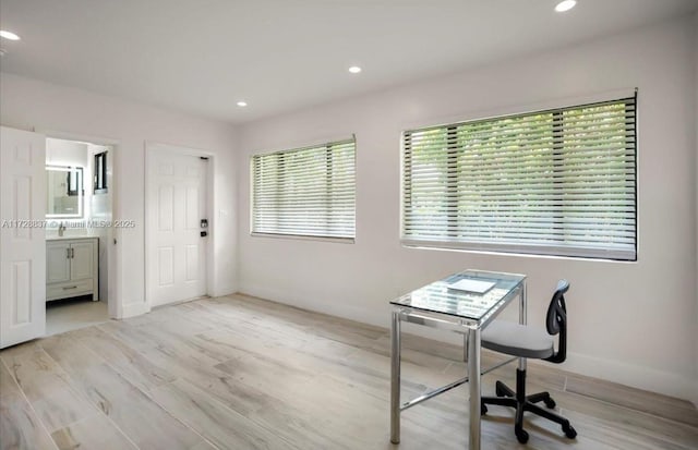 office space with light hardwood / wood-style floors and sink