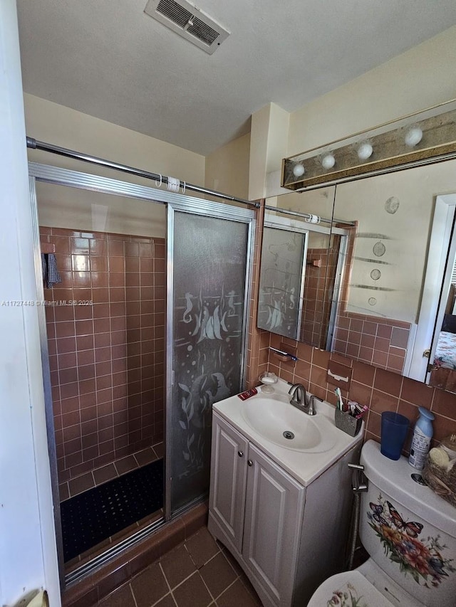 bathroom with visible vents, tile walls, vanity, and tile patterned floors