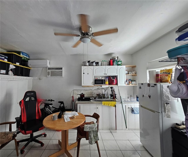 kitchen featuring black microwave, light tile patterned flooring, white cabinetry, freestanding refrigerator, and open shelves