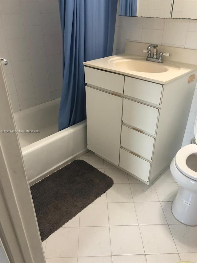 bathroom with backsplash, toilet, shower / bath combo, vanity, and tile patterned floors