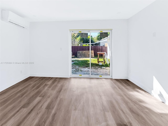 empty room featuring hardwood / wood-style floors and a wall unit AC